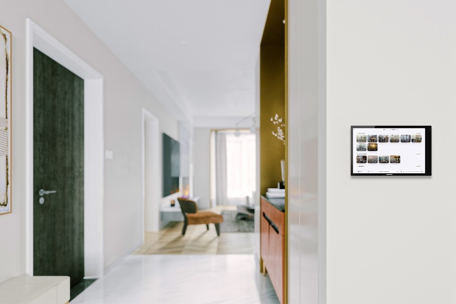 A home with a Crestron Home control touchscreen on the wall.